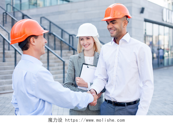 建筑工程师在施工场地握手Professional construction team made a deal with handshake